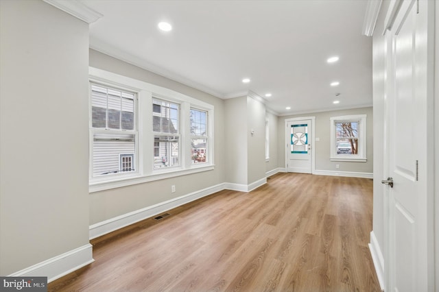 interior space with ornamental molding, a healthy amount of sunlight, and light hardwood / wood-style floors