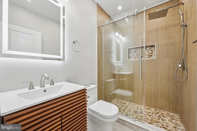 bathroom with vanity, toilet, and a shower with shower door