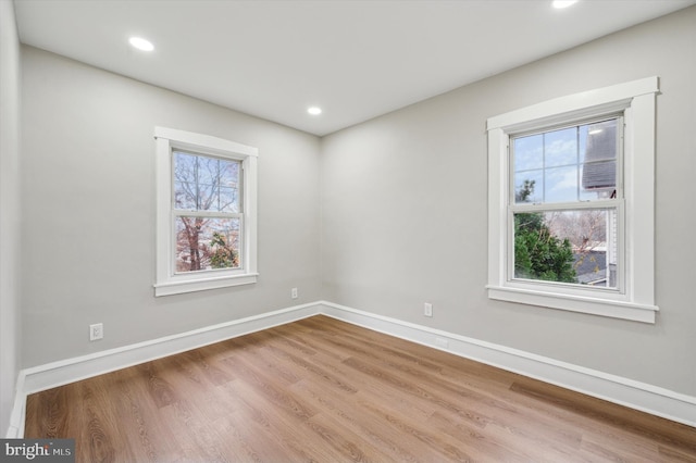 unfurnished room featuring plenty of natural light and hardwood / wood-style floors