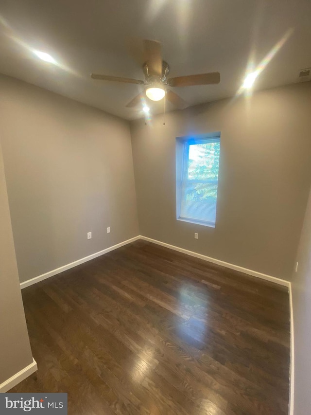 empty room featuring ceiling fan and dark hardwood / wood-style flooring