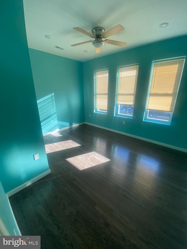 unfurnished room with dark wood-type flooring and ceiling fan