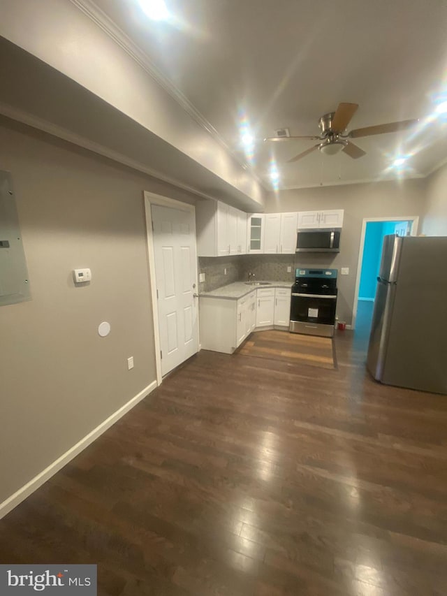 kitchen with appliances with stainless steel finishes, sink, white cabinets, decorative backsplash, and dark hardwood / wood-style floors