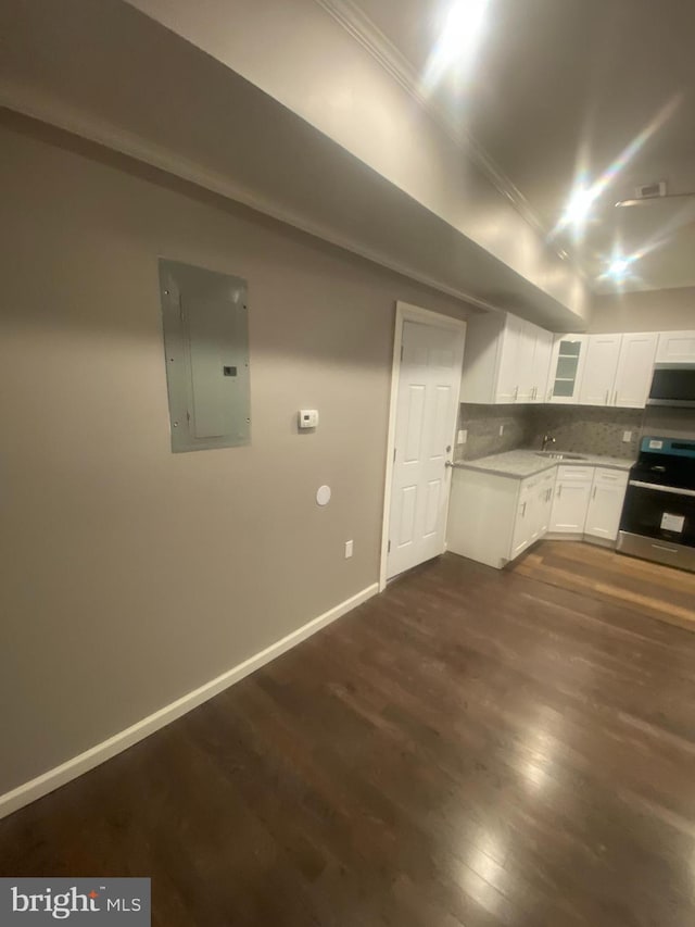 kitchen featuring decorative backsplash, electric panel, extractor fan, white cabinetry, and stainless steel range