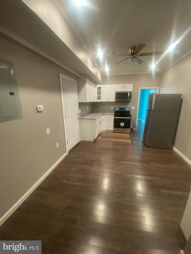 kitchen with tasteful backsplash, dark hardwood / wood-style flooring, stainless steel appliances, white cabinets, and electric panel