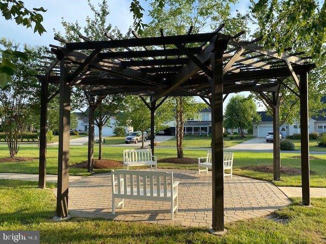 surrounding community featuring a pergola and a lawn