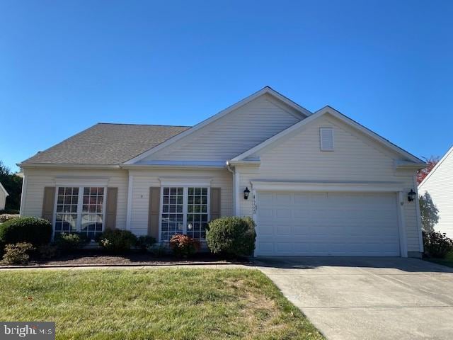 single story home with a garage and a front lawn