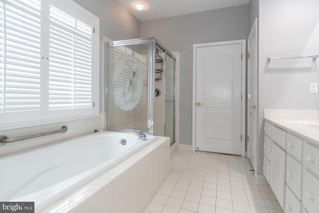 bathroom featuring shower with separate bathtub, vanity, and tile patterned floors