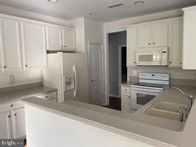 kitchen featuring white appliances, white cabinetry, and sink