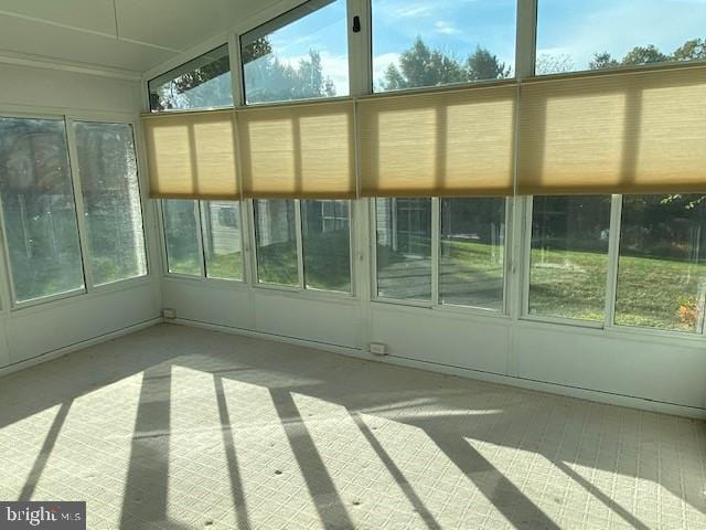 unfurnished sunroom featuring a healthy amount of sunlight and vaulted ceiling