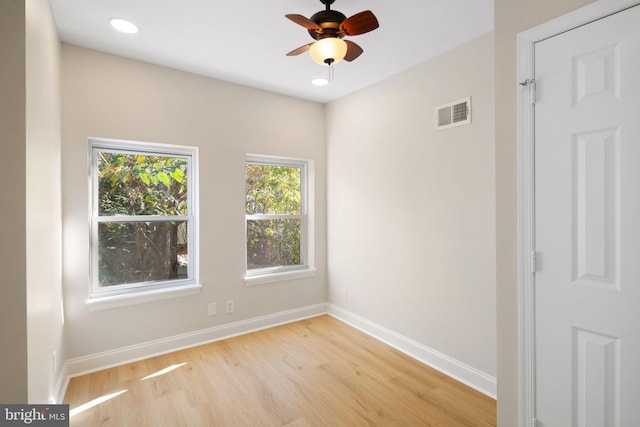 empty room with ceiling fan and light hardwood / wood-style flooring