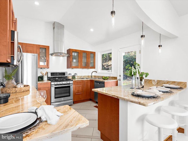 kitchen featuring kitchen peninsula, appliances with stainless steel finishes, light stone counters, vaulted ceiling, and hanging light fixtures