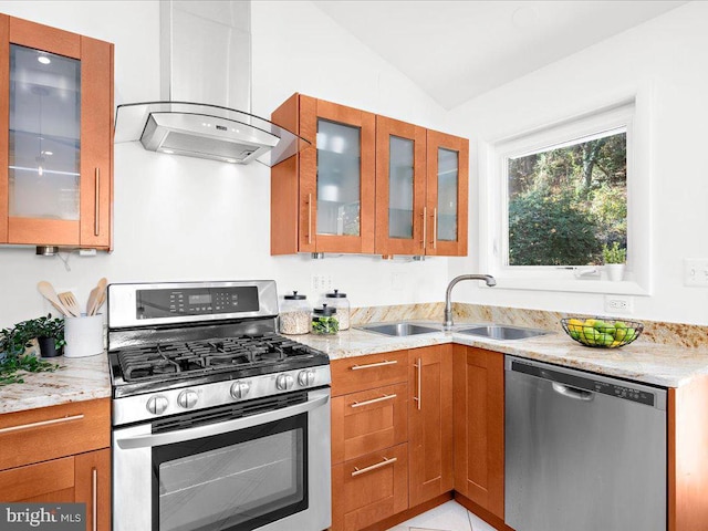 kitchen with lofted ceiling, sink, light stone countertops, appliances with stainless steel finishes, and island range hood