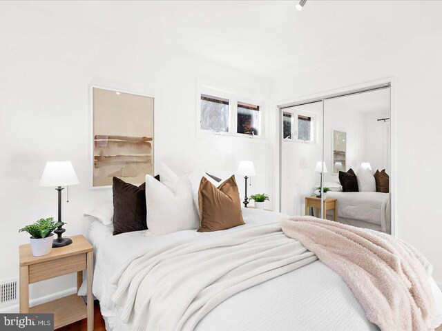 bedroom with hardwood / wood-style floors and a closet