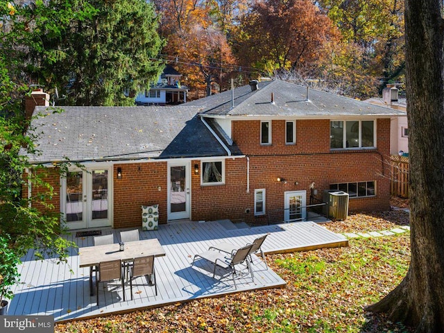 rear view of property featuring a wooden deck and central AC