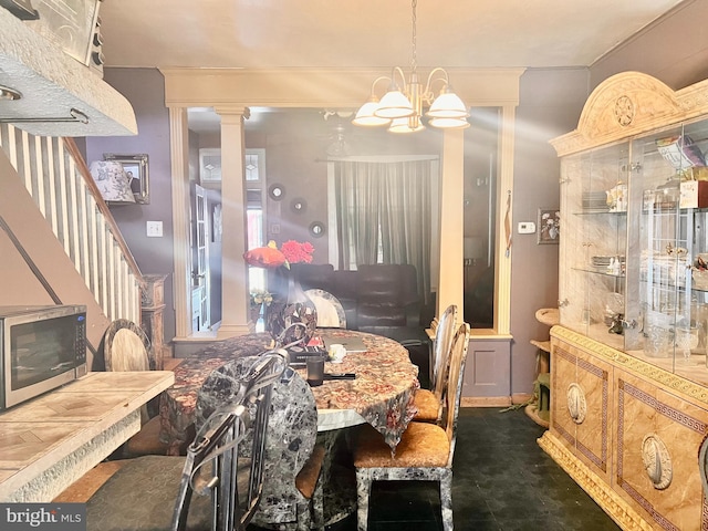 dining area with ornamental molding, a chandelier, and ornate columns