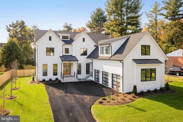 modern farmhouse style home featuring a front lawn and a garage