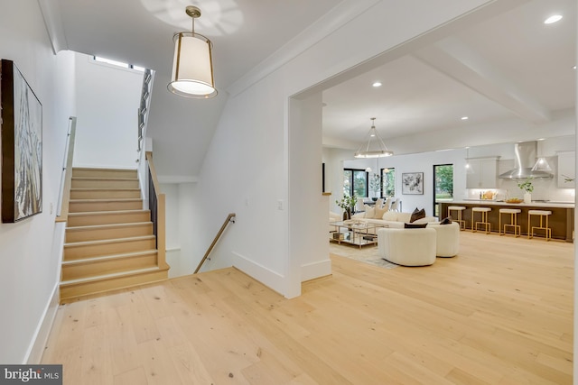 stairs with ornamental molding and wood-type flooring