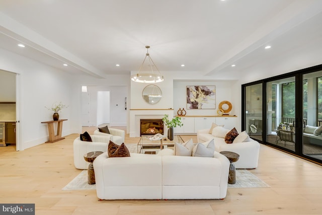 living room featuring light hardwood / wood-style floors, wine cooler, beam ceiling, and an inviting chandelier