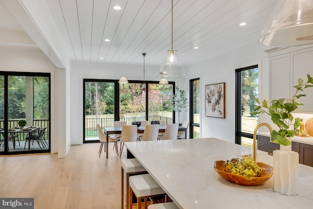 dining space featuring light hardwood / wood-style floors and wood ceiling