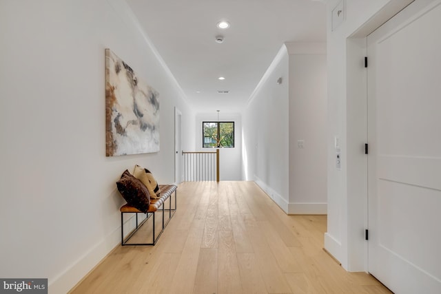 corridor with crown molding and light wood-type flooring