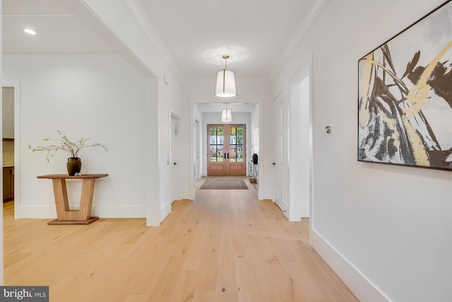 corridor with french doors, hardwood / wood-style flooring, and ornamental molding