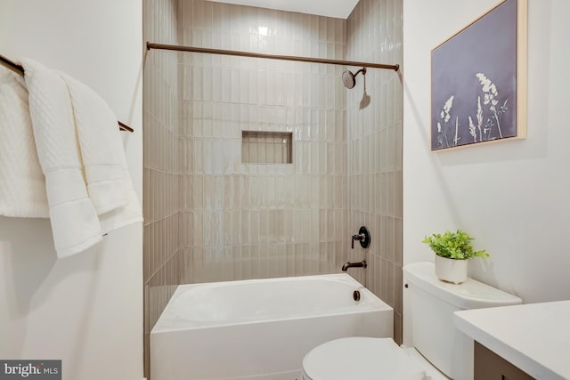 full bathroom featuring tiled shower / bath, vanity, and toilet