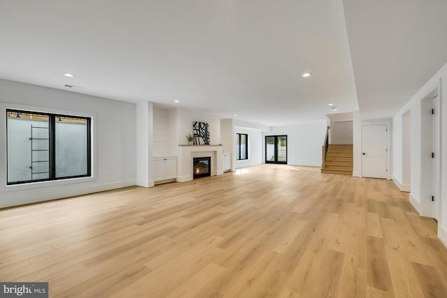 unfurnished living room with light hardwood / wood-style flooring and plenty of natural light