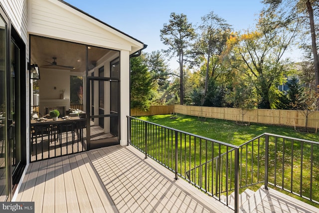 wooden terrace with a lawn, a sunroom, and ceiling fan