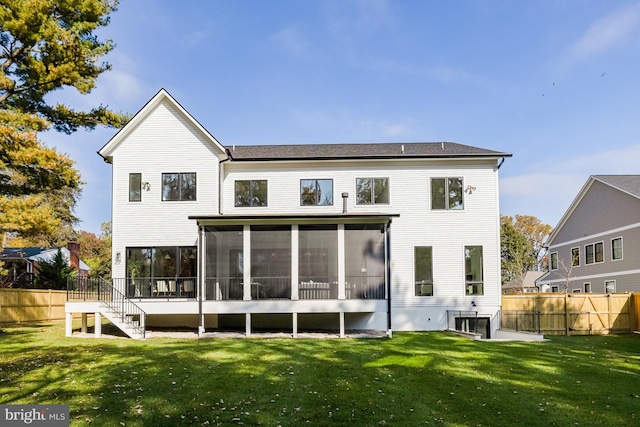 rear view of house with a yard and a sunroom