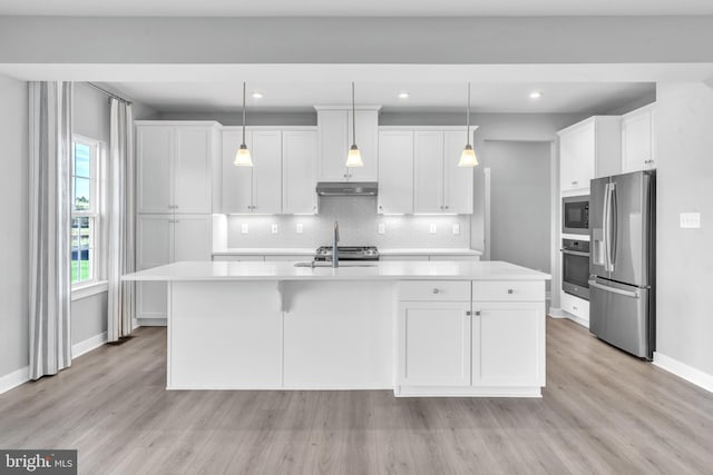 kitchen featuring appliances with stainless steel finishes, white cabinets, a kitchen island with sink, and hanging light fixtures