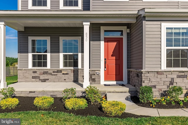 view of exterior entry featuring covered porch