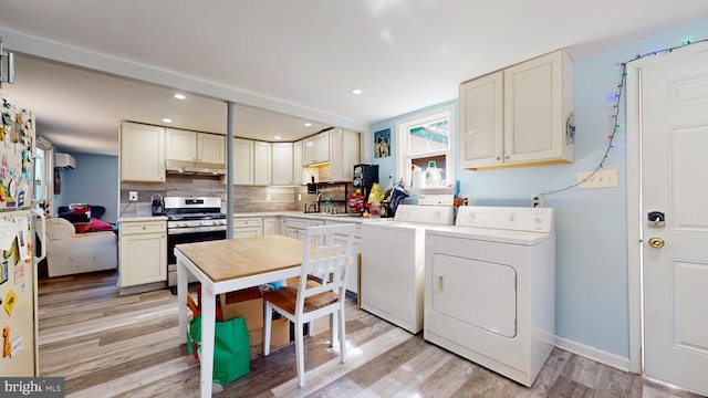 kitchen with sink, separate washer and dryer, backsplash, stainless steel range with gas stovetop, and light hardwood / wood-style floors