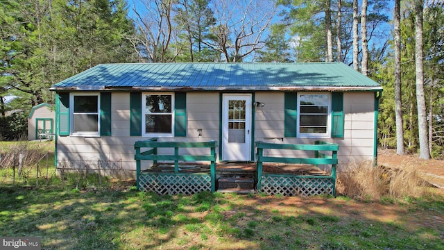 view of front facade with a wooden deck and a front yard