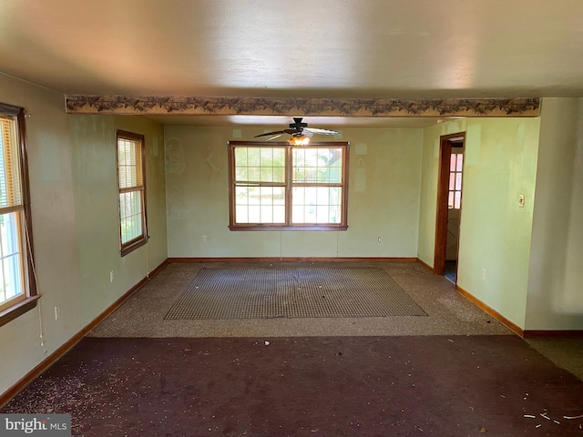 carpeted spare room featuring ceiling fan and a wealth of natural light