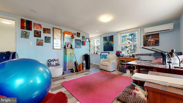 office area with an AC wall unit and light hardwood / wood-style floors