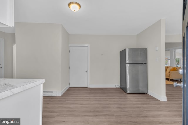 kitchen featuring baseboard heating, stainless steel fridge, and light hardwood / wood-style floors