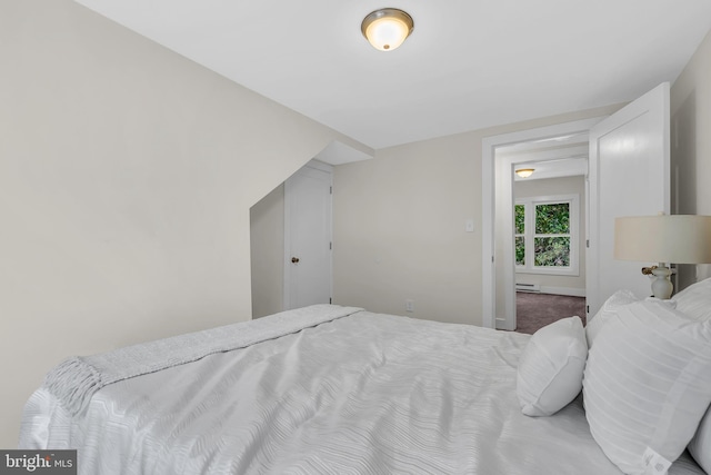 bedroom with a baseboard heating unit and carpet