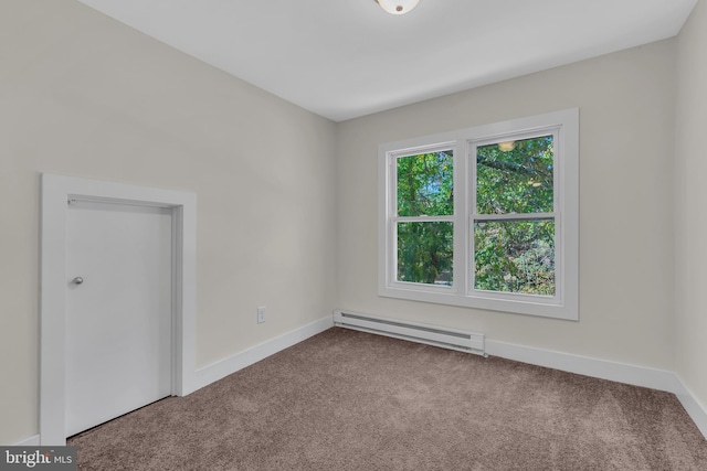 carpeted spare room featuring a baseboard heating unit