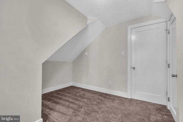 bonus room featuring lofted ceiling and dark carpet