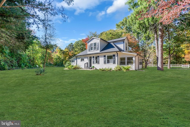 rear view of house featuring a lawn