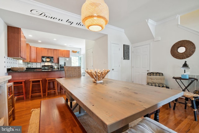 dining area with hardwood / wood-style floors and crown molding