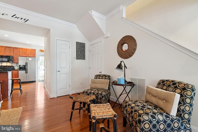 sitting room with light hardwood / wood-style flooring and crown molding