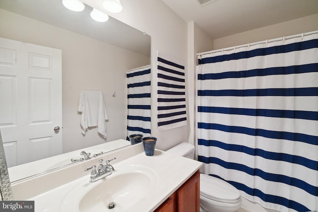 bathroom featuring toilet, a shower with curtain, and vanity