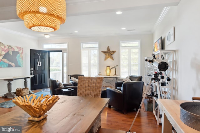 dining space featuring ornamental molding, a wealth of natural light, and hardwood / wood-style flooring