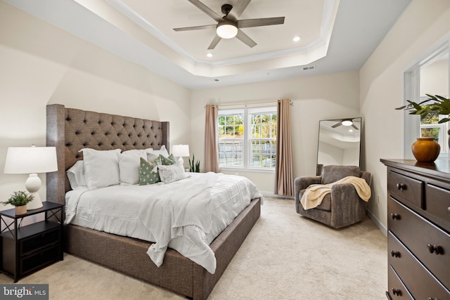 carpeted bedroom featuring ceiling fan, ornamental molding, and a tray ceiling