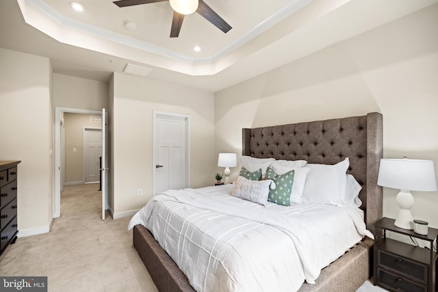 carpeted bedroom featuring ceiling fan and a raised ceiling