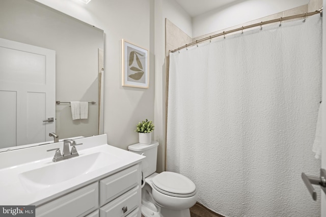 bathroom featuring curtained shower, vanity, and toilet