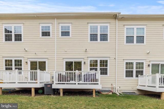 back of house featuring a lawn, a wooden deck, and cooling unit