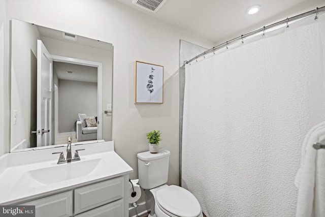 bathroom featuring curtained shower, vanity, and toilet