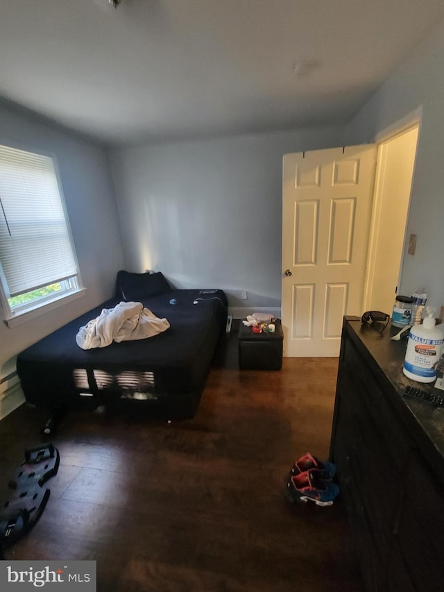 bedroom with dark hardwood / wood-style flooring